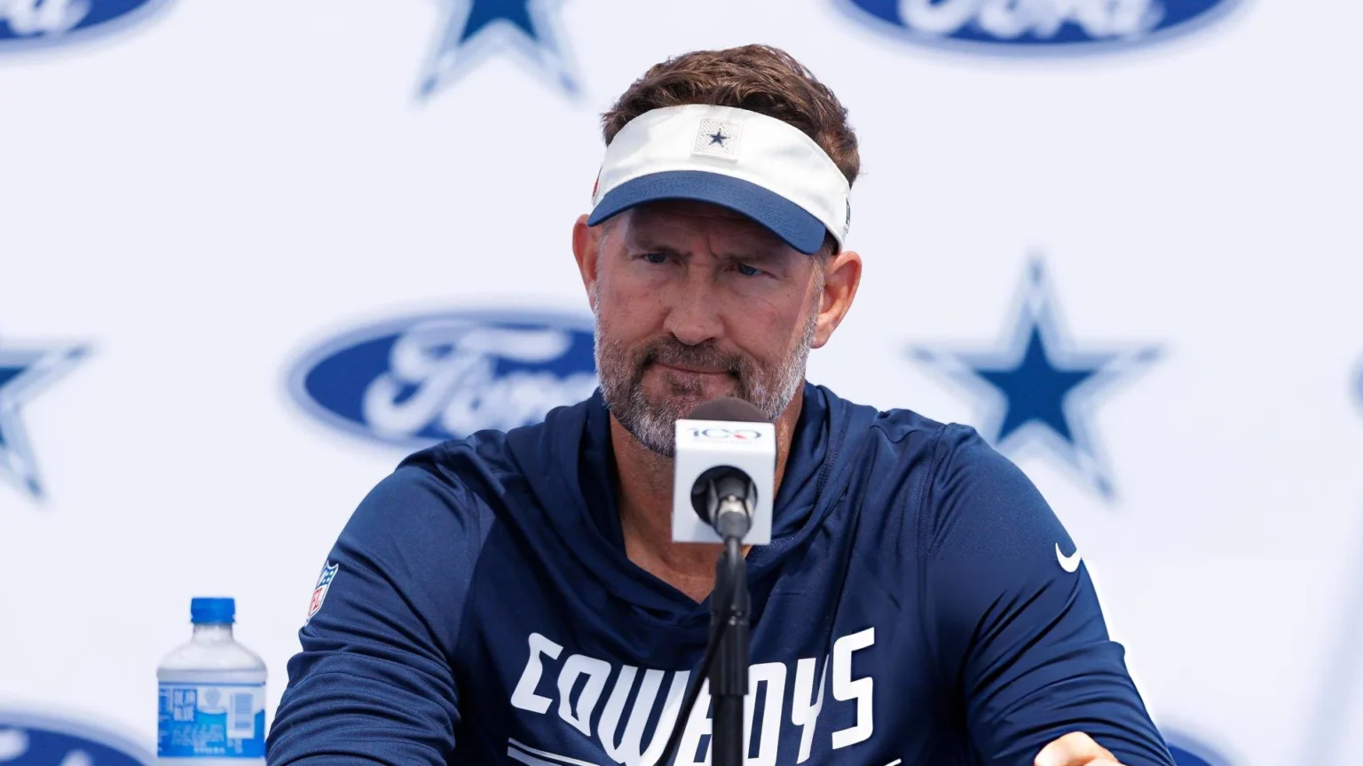 Head coach Brian Schottenheimer of the Dallas Cowboys speaks with members of the media during training camp at River Ridge Playing Fields